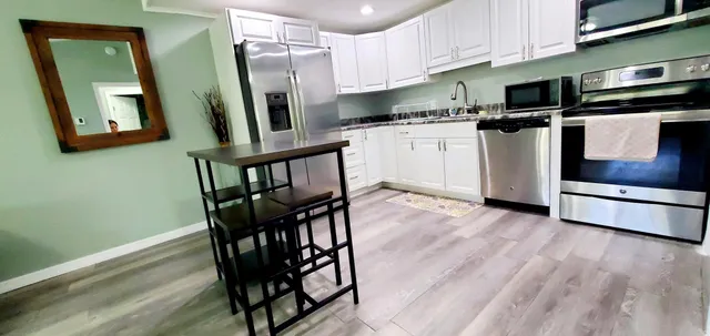 a kitchen with stainless steel appliances wooden floors and wooden cabinets