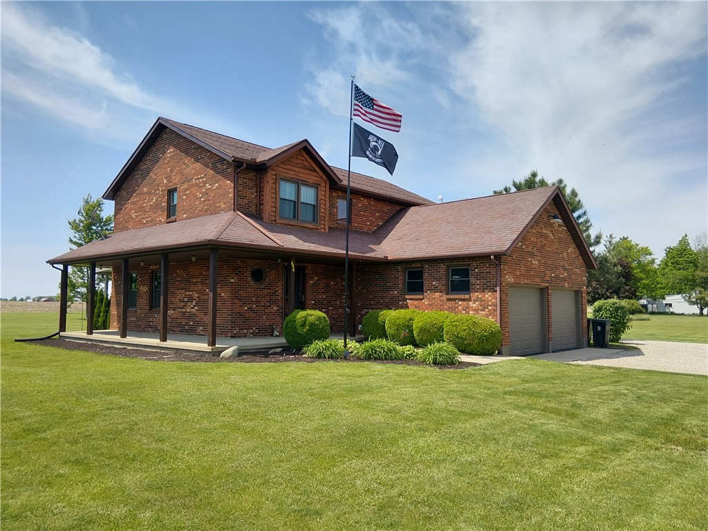 646 North Rangeline Road Pleasant Hill, OH 45359 - Photo 7 of 11 This brick residence offers a welcoming wrap-around porch and an integrated two-car garage, set amidst verdant grounds.