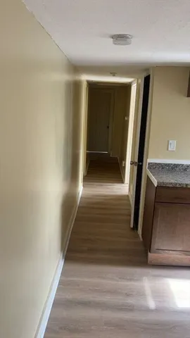a view of a hallway with wooden floor and staircase