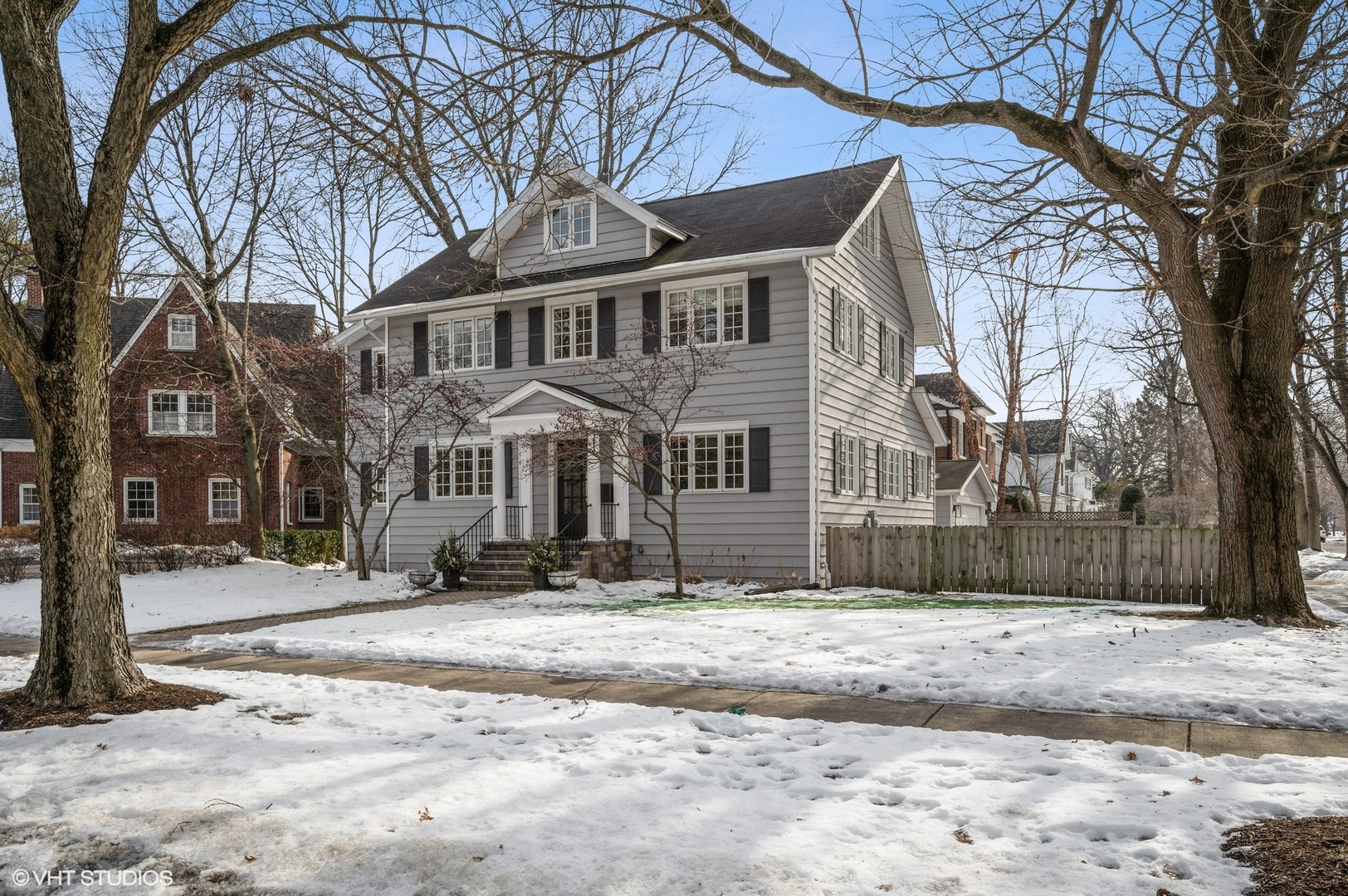 402 Willow Road Winnetka, IL 60093 - Photo 1 of 31 a view of a white house with a yard covered in snow