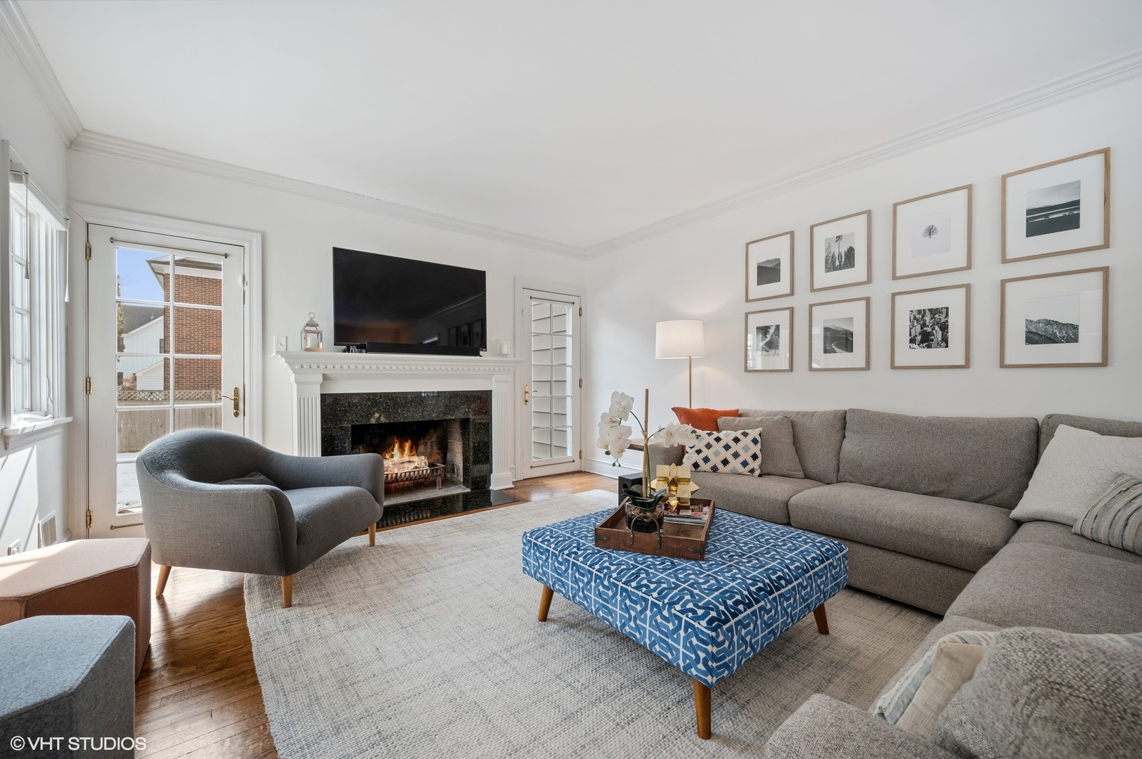 402 Willow Road Winnetka, IL 60093 - Photo 2 of 31 a living room with furniture a rug a flat screen tv and a fireplace