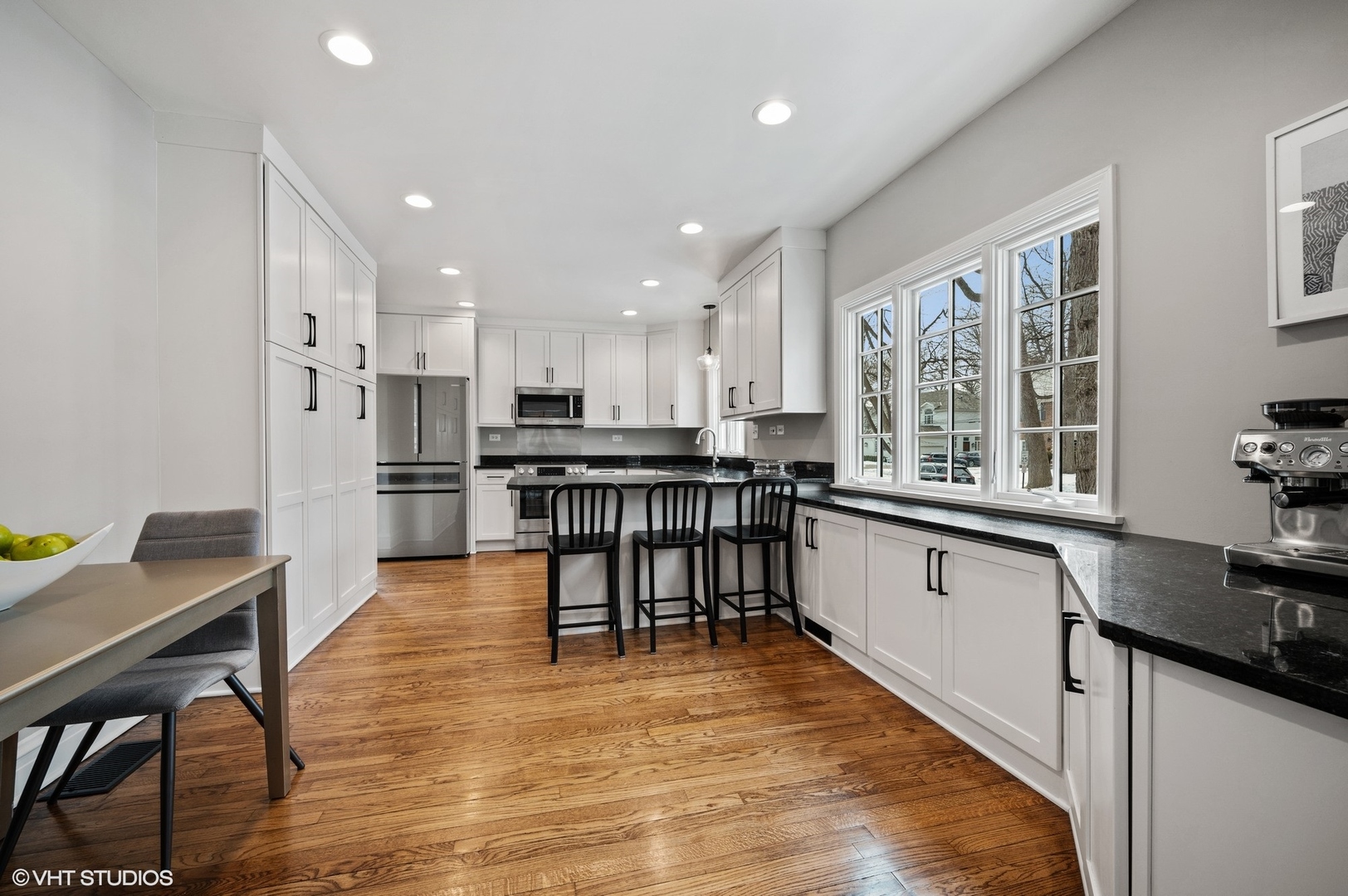 402 Willow Road Winnetka, IL 60093 - Photo 9 of 31 a kitchen with stainless steel appliances kitchen island granite countertop a table chairs sink and cabinets