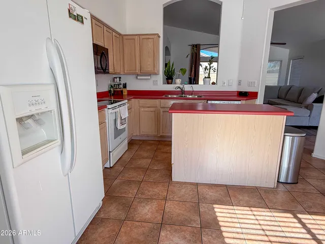 a kitchen with a sink a refrigerator and cabinets