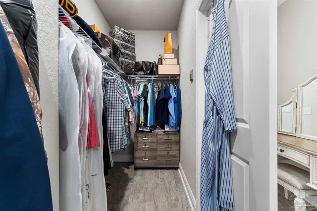 a view of walk in closet with clothes and shoes