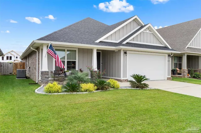 a front view of a house with a yard and potted plants