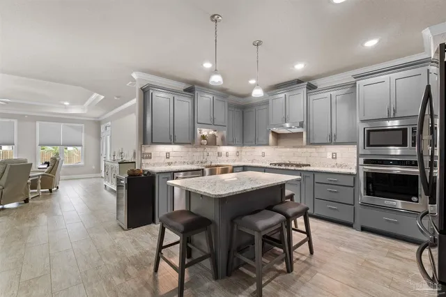 a kitchen with kitchen island granite countertop wooden cabinets and stainless steel appliances