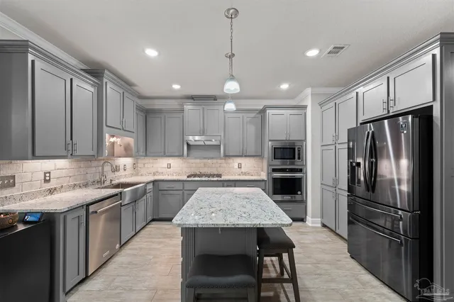 a kitchen with a center island appliances and cabinets