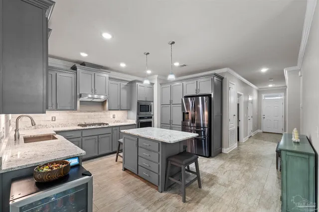 a kitchen with stainless steel appliances granite countertop a sink stove and refrigerator