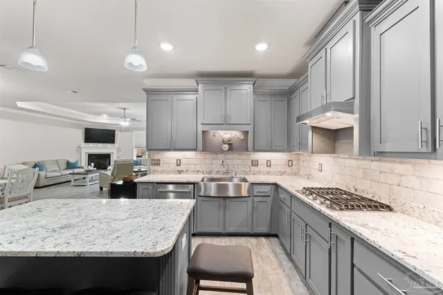 a kitchen with kitchen island granite countertop a sink stove and cabinets