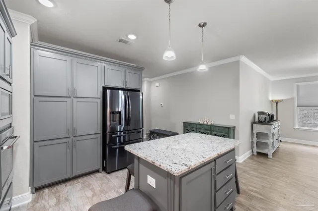 a kitchen with kitchen island a refrigerator stove and microwave