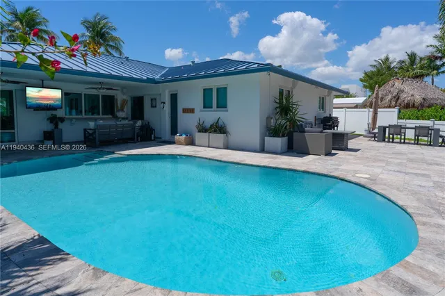 a view of a house with a swimming pool and sitting area