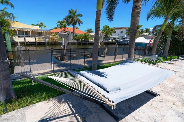 a view of a patio with table and chairs potted plants and palm tree