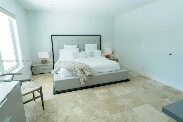 a bedroom with a bed chair and a window