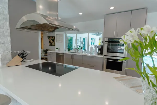 a open dining room with furniture a chandelier and kitchen view