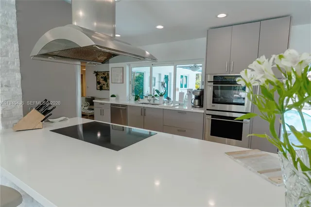 a open dining room with furniture a chandelier and kitchen view