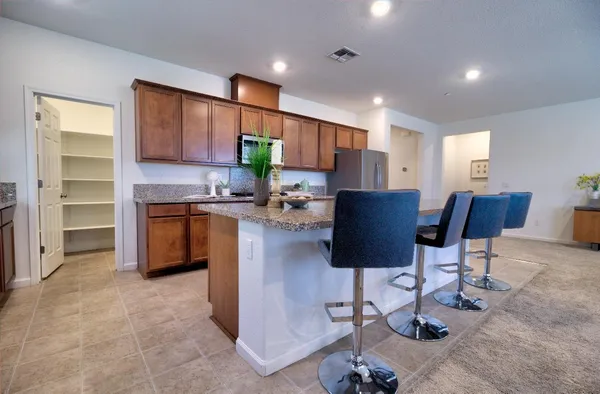 a kitchen with stainless steel appliances granite countertop wooden cabinets granite counter tops and a stove top oven