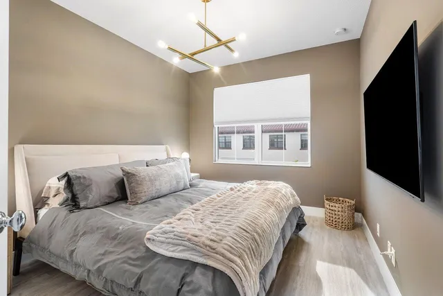 a bedroom with a bed and wooden floor