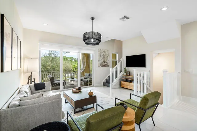 a living room with furniture a flat screen tv and a large window