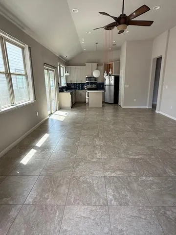 an empty room with windows and fireplace
