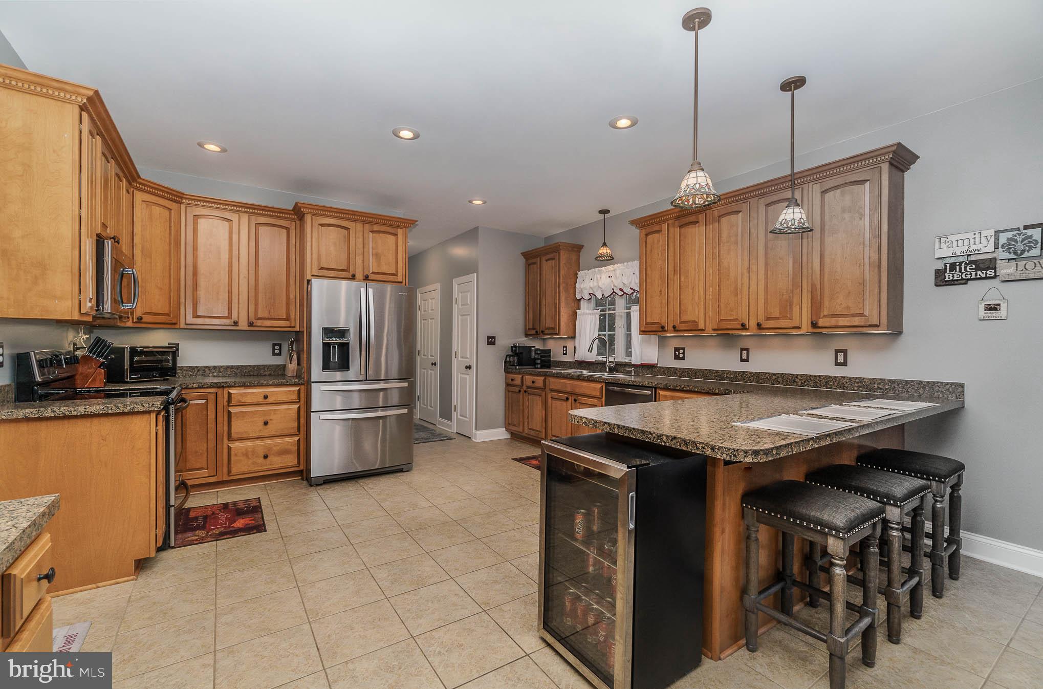 2375 Carrollton Road Westminster, MD 21157 - Photo 9 of 37 a kitchen with stainless steel appliances granite countertop a stove a sink dishwasher and a refrigerator with wooden cabinets