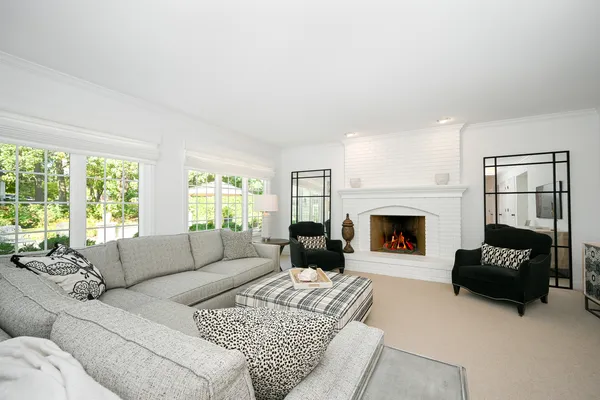 a living room with furniture a fireplace and a large window