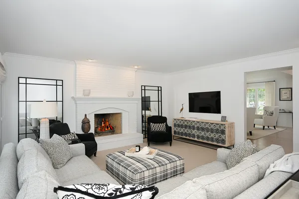 a living room with furniture a fireplace and a flat screen tv