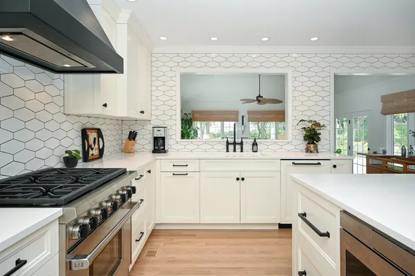 a kitchen with white cabinets and appliances