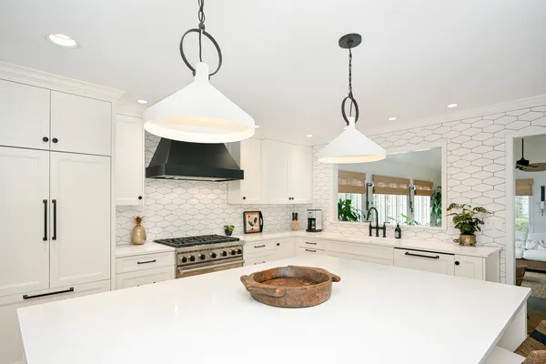 a kitchen with stainless steel appliances a stove a sink and a chandelier
