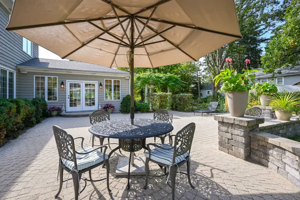a patio with a table and chairs under an umbrella