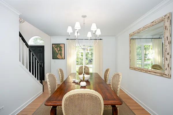 a dining room with furniture a chandelier and wooden floor