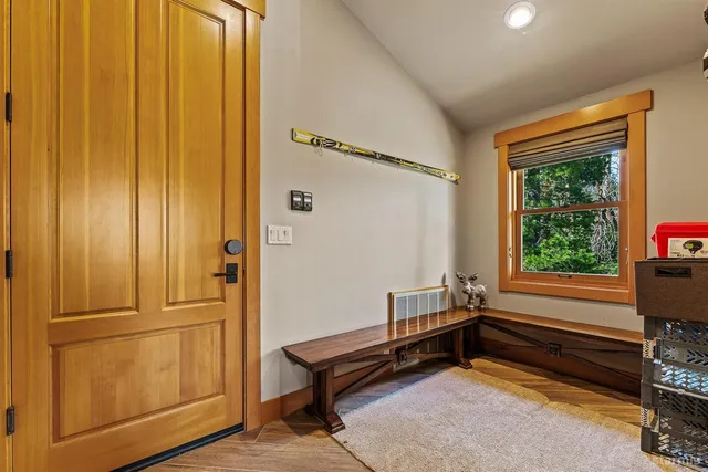 a view of an empty room with wooden floor and windows
