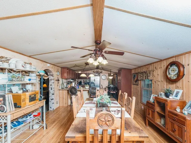 a room with lots of wooden furniture and stainless steel appliances