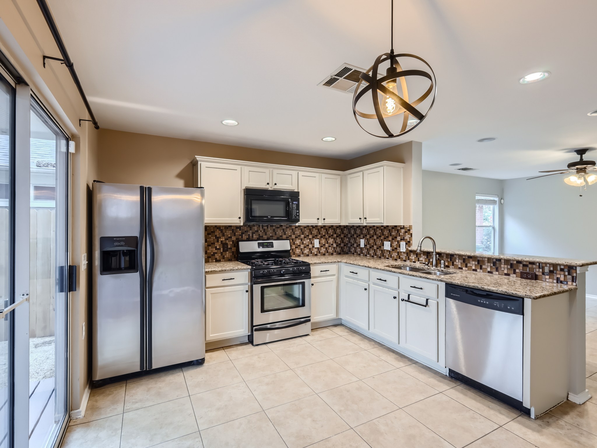 5814 Steven Creek Way Austin, TX 78721 - Photo 3 of 15 a kitchen with stainless steel appliances granite countertop a stove top oven a refrigerator a sink and dishwasher