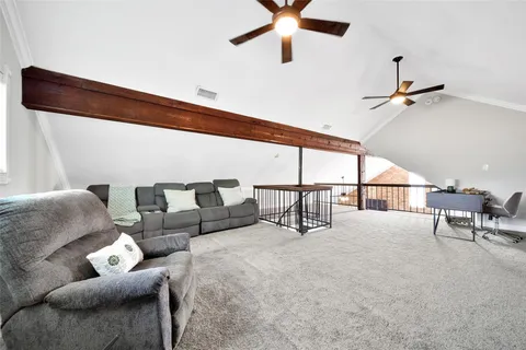a living room with furniture and a ceiling fan