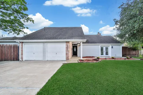 a front view of a house with a garden and trees