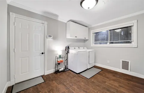 a utility room with cabinets washer and dryer