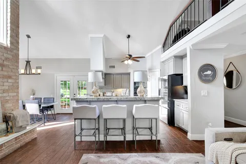 a kitchen with stainless steel appliances a dining table chairs stove and cabinets