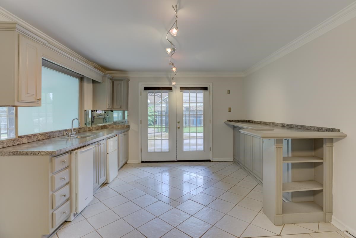 7194 Crestridge Road Memphis, TN 38119 - Photo 9 of 25 Gathering room/bar off of the kitchen with sink, ice maker and double doors that lead to the patio.