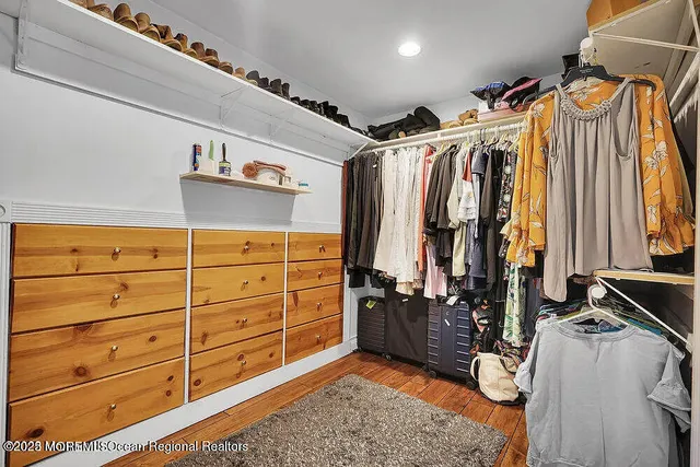 a view of walk in closet with clothes and shoes