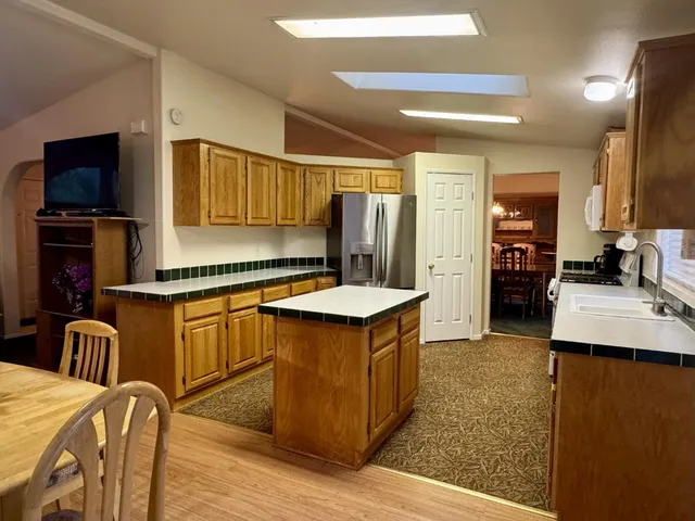a kitchen with stainless steel appliances kitchen island granite countertop a stove and a refrigerator