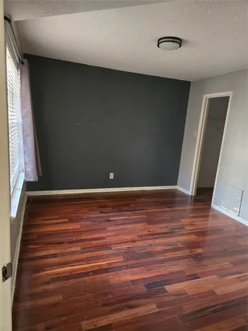 a view of room with window and wooden floor