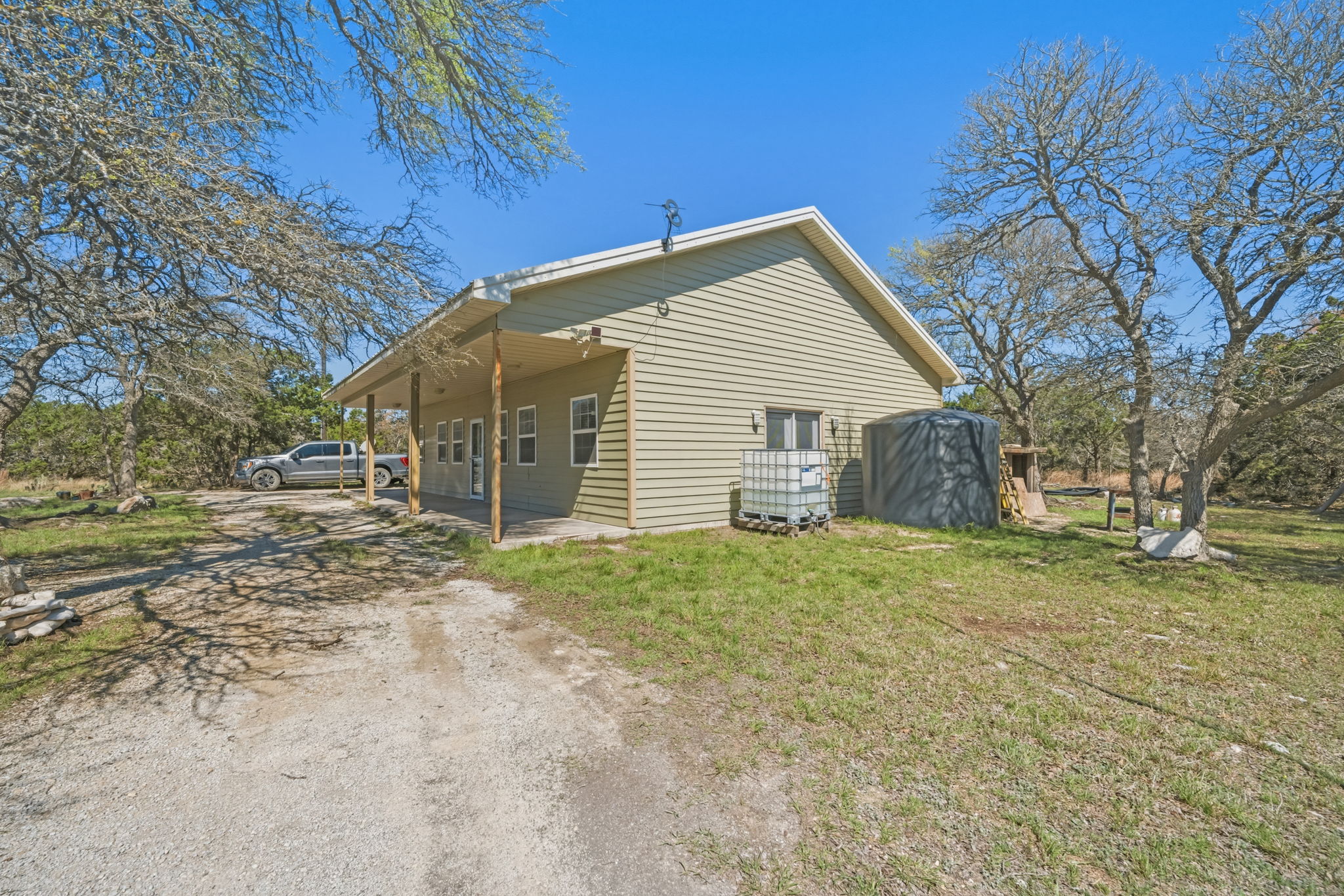 1301 Altwein Road Blanco, TX 78606 - Photo 30 of 40 View of home's exterior featuring driveway and a lawn