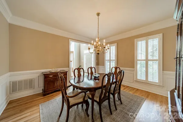 a living room with furniture and a piano next to a window