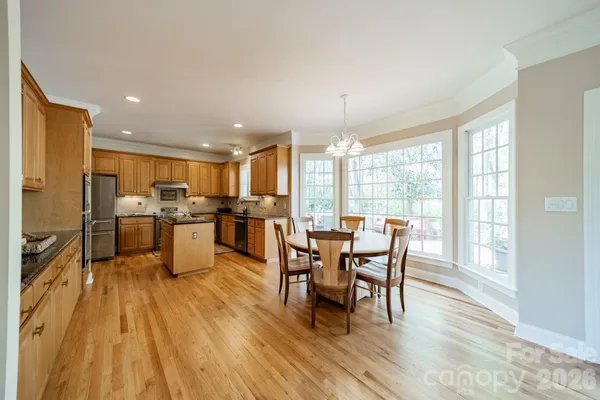 a large kitchen with lots of counter top space a sink stainless steel appliances and cabinets
