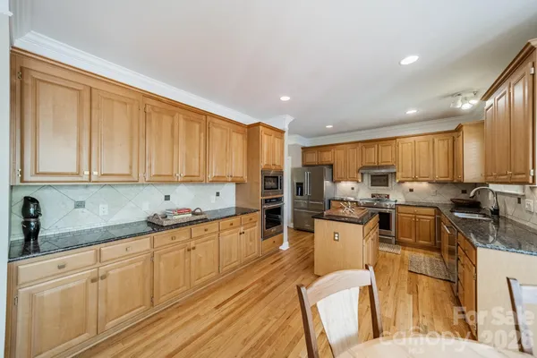 a kitchen with granite countertop a stove top oven sink and cabinets