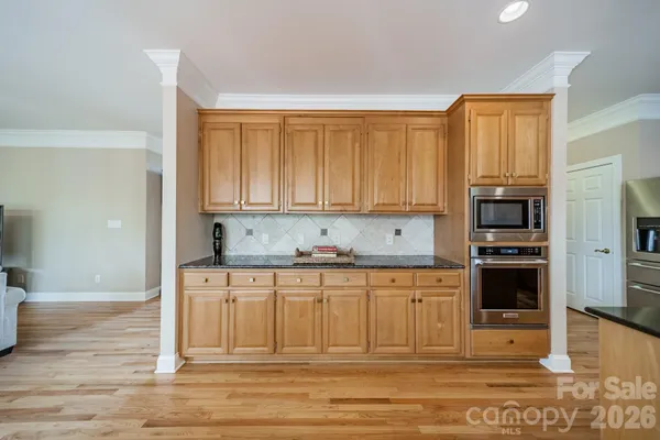 an open kitchen with granite countertop a stove and a refrigerator
