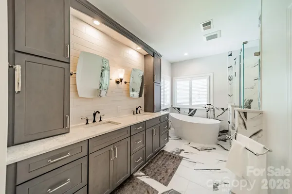a white bath tub sitting next to a white sink and glass door