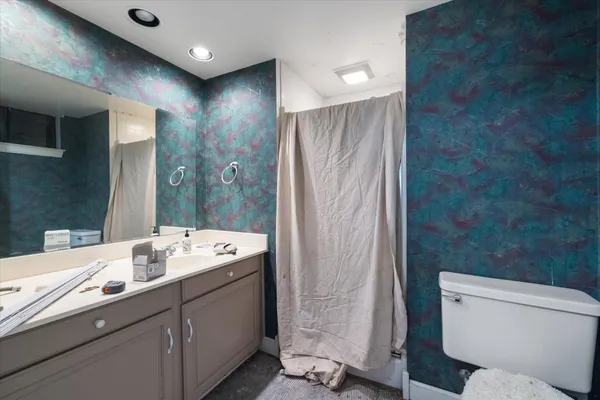 a bathroom with a double vanity sink toilet and a mirror