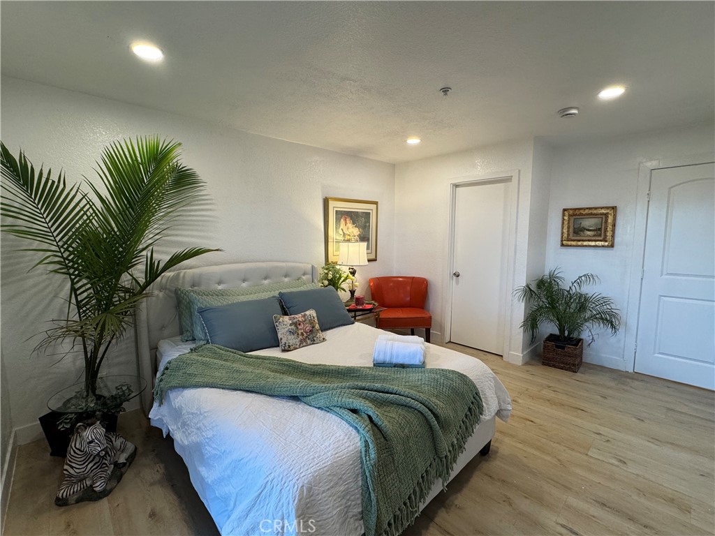 a bedroom with a large bed and a potted plant