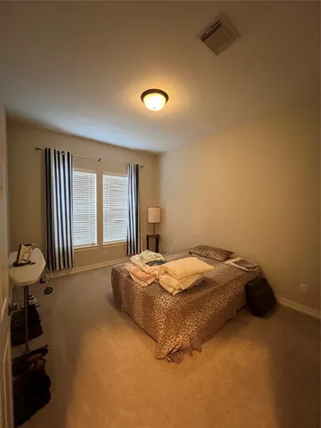 a spacious bedroom with a bed and a large window